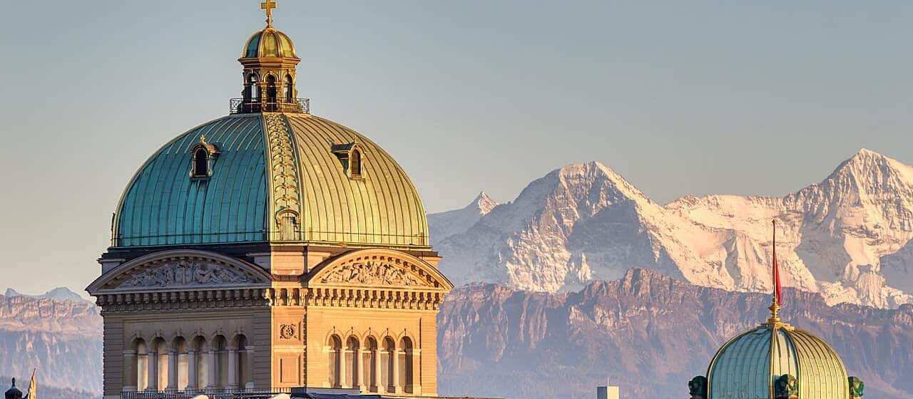 The domes of the Federal Palace (Bundeshaus) in Bern at dusk