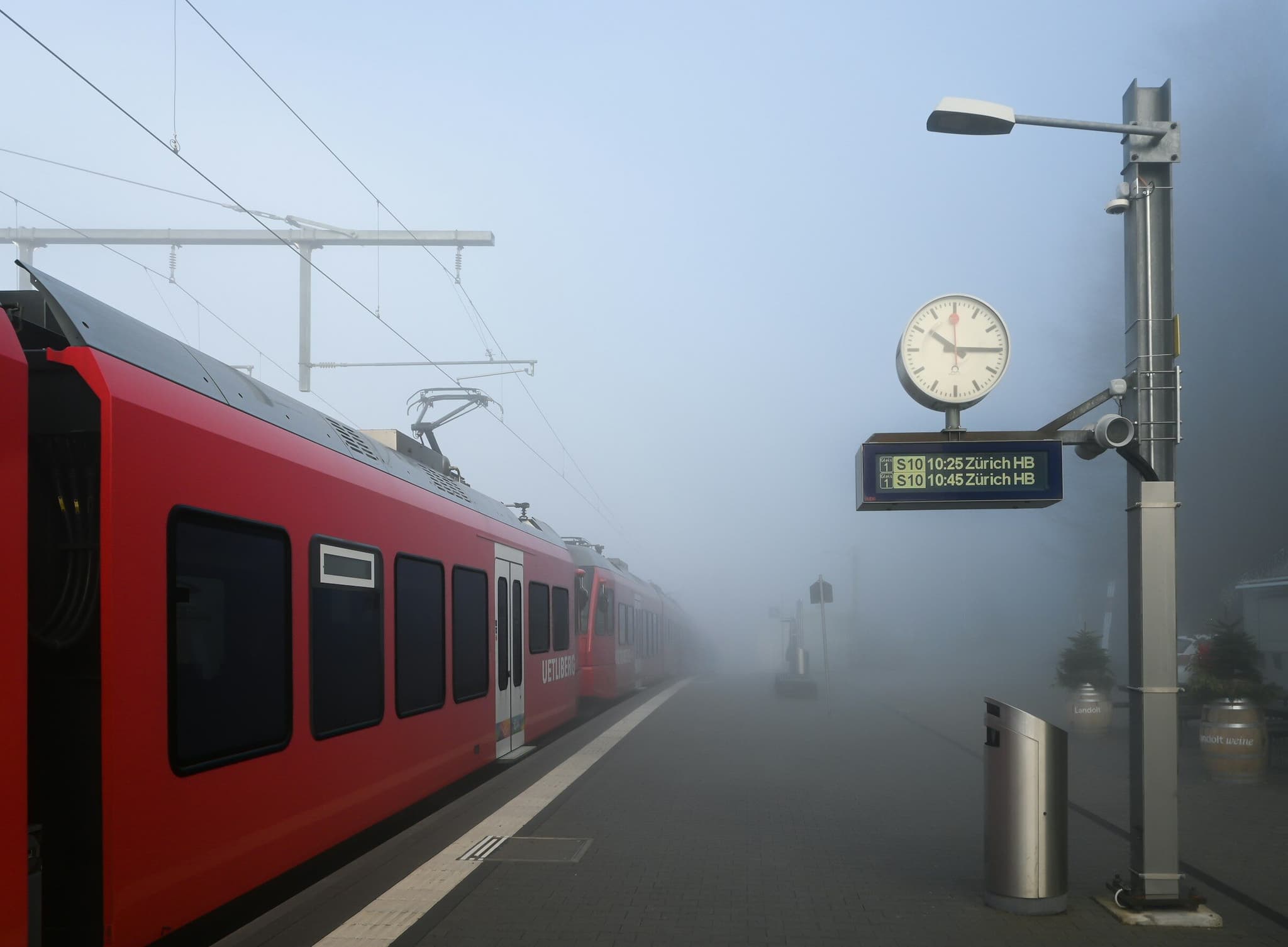 Regionalzug an einem nebligen Bahnsteig — grenzüberschreitende Mobilität